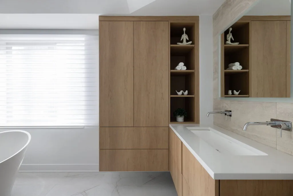High-end condominium bathroom featuring a custom-built vanity designed with premium materials, refined craftsmanship, and elegant finishes. The integrated storage and sophisticated detailing create a functional yet luxurious focal point that enhances the overall modern bathroom design.
